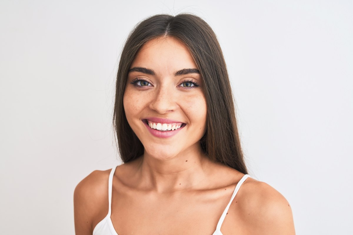 The portrait after frequency-separation retouching: skin tone is even and blemishes are gone, but pores and texture remain.